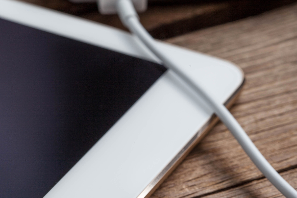 Tablette avec un câble de charge connecté mais affichant une icône de batterie vide