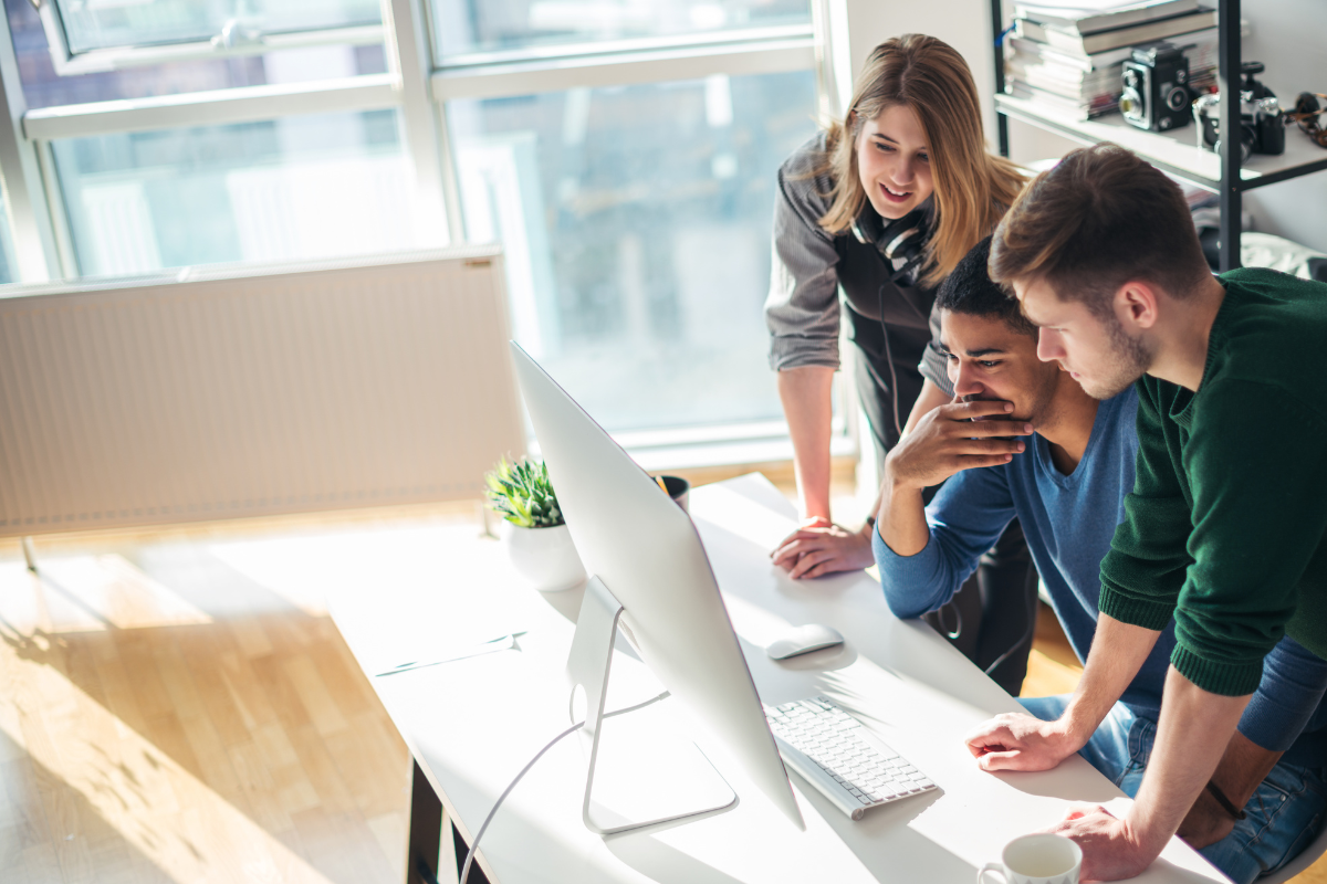 Équipe de communication travaillant autour d'un tableau avec un plan de communication détaillé