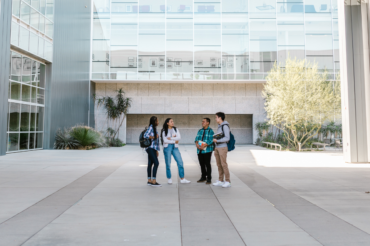 Un campus d'une école de commerce avec des étudiants discutant à l'extérieur